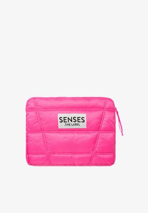 Padded pink laptop sleeve with diagonal stitching, featuring a white label with black text, and a zip closure on the side.