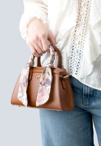 Brown leather handbag with a structured shape, featuring a decorative floral scarf tied around the handles. Smooth texture and gold hardware detail.