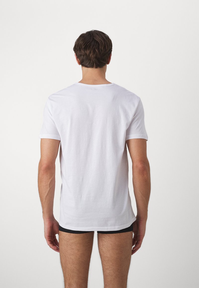 White cotton t-shirt with short sleeves, crew neckline, and a relaxed fit. Smooth texture with no visible patterns or graphics.