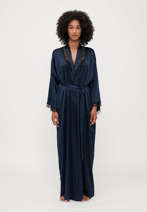 Robe en satin navy avec dentelle au niveau du col et des manches, dotée d'une taille à lien et d'une silhouette longue et fluide. Texture lisse, design minimal.
