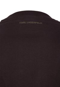 Czarny T-shirt z żebrowanym okrągłym dekoltem i małym wytłoczonym logo z tyłu, wykonany z miękkiej bawełny.