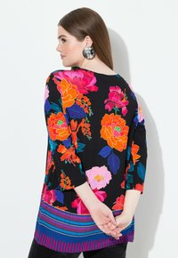 Mustat yläosat, joissa on suuria, eloisia kukkakuosisia printtejä punaisena, oranssina, vaaleanpunaisena ja sinisenä, kolmannes hihan kanssa ja kuviollinen helma.