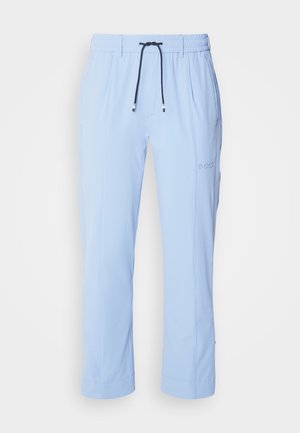 Lyseblå, lette joggebukser med elastisk midje, snøring og diskrete sidelommer. Har merkevarenlogo på høyre ben.