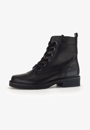 Schwarze Leder-Ankle-Boots mit sechs Ösen, runder Zehenpartie, strukturiertem Obermaterial und einer robusten Gummisohle. Mit einem Ziehlappen an der Rückseite.