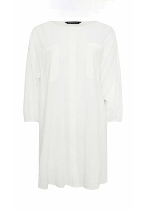 Witte lange mouwen jurk met knoopsluiting, twee borstzakken en een ronde halslijn, weergegeven op een effen achtergrond.