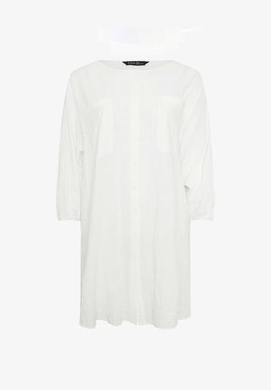 Weißes, langärmliges Hemdkleid mit zwei Brusttaschen und rundem Ausschnitt, vor einfachem Hintergrund präsentiert.