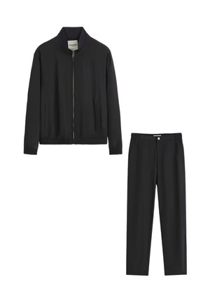 Veste noire zippée avec col montant et poignets élastiques, associée à un pantalon à taille élastique assorti, les deux présentant une texture lisse.
