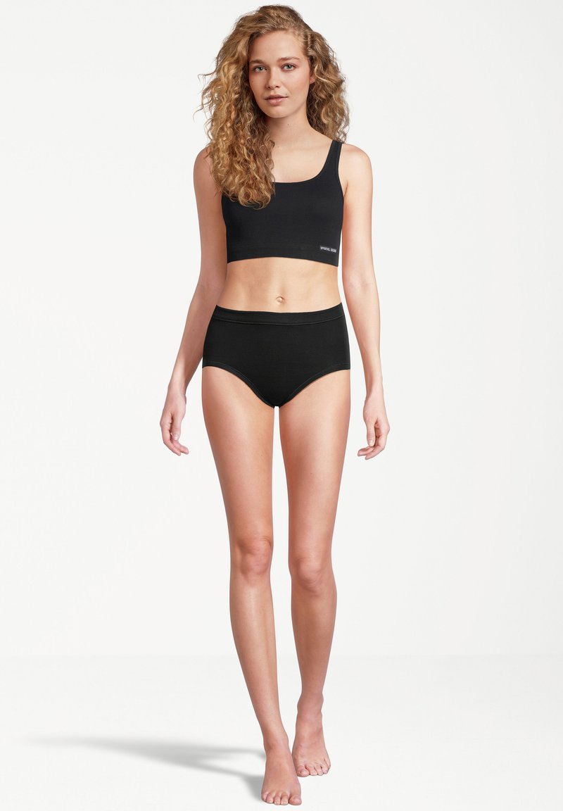 Black cotton crop top and high-waisted briefs. Soft texture, minimal design with no visible patterns. Simple, comfortable fit.