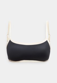 Μαύρο και μπεζ crop top με ρυθμιζόμενους λεπτούς ιμάντες, με ίσια λαιμόκοψη, απλωμένο σε λευκή επιφάνεια.