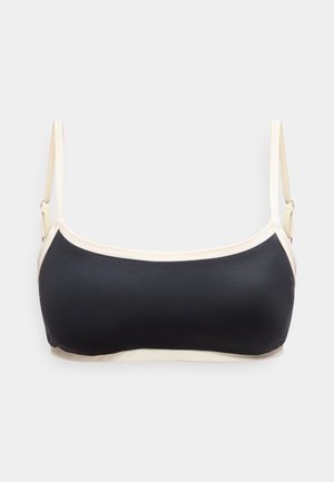 Μαύρο και μπεζ crop top με ρυθμιζόμενους λεπτούς ιμάντες, με ίσια λαιμόκοψη, απλωμένο σε λευκή επιφάνεια.