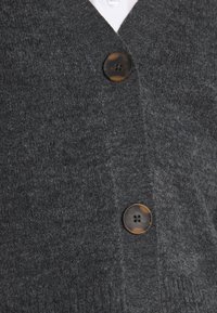 Grauer gestrickter Cardigan mit V-Ausschnitt, zwei Knöpfen mit Schildpattmuster und einem weichen, strukturierten Stoff.