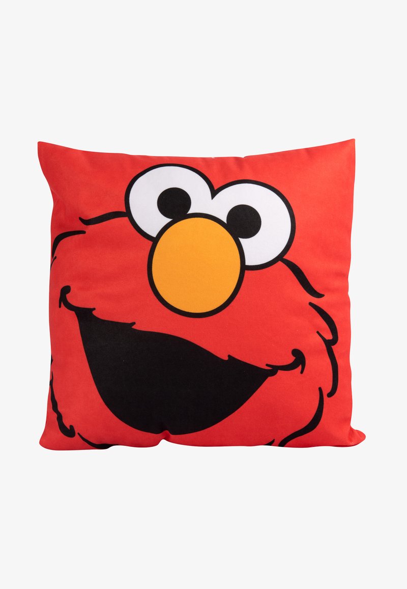 Cuscino rosso con il volto di un personaggio dei cartoni animati, caratterizzato da grandi occhi bianchi, un naso arancione e una bocca nera sorridente, su uno sfondo piatto.