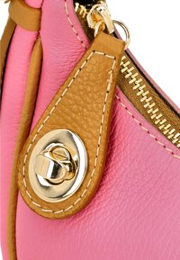 Geantă de piele roz cu accente bej, având un fermoar auriu și un detaliu de închidere metalic rotund. Textura este netedă, cu cusături vizibile.
