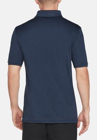 Marineblaues Poloshirt mit kurzen Ärmeln und Kragen, das eine saubere, glatte Textur und einen geraden Saum aufweist. Einfaches Design ohne sichtbare Logos.