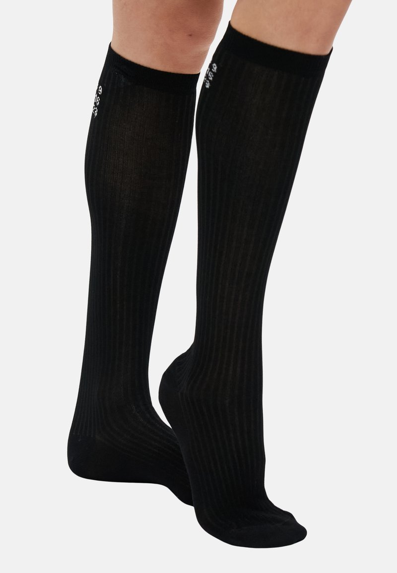 Black knee-high socks with a ribbed texture, featuring small decorative accents near the top. Made from a smooth, stretchy material.