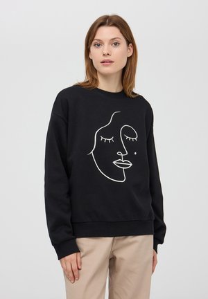 Felpa nera in cotone con un design di un volto in linea bianca. La vestibilità è comoda con polsini e orlo a costine.