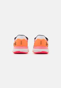 Des chaussures de sport rouges et blanches avec une tige en maille, des accents orange vif, un col rembourré et une semelle texturée pour l'adhérence.