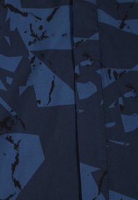 Navy stof met abstracte geometrische patronen in donkere tinten en zwarte accenten. De textuur lijkt glad met een lichte glans.