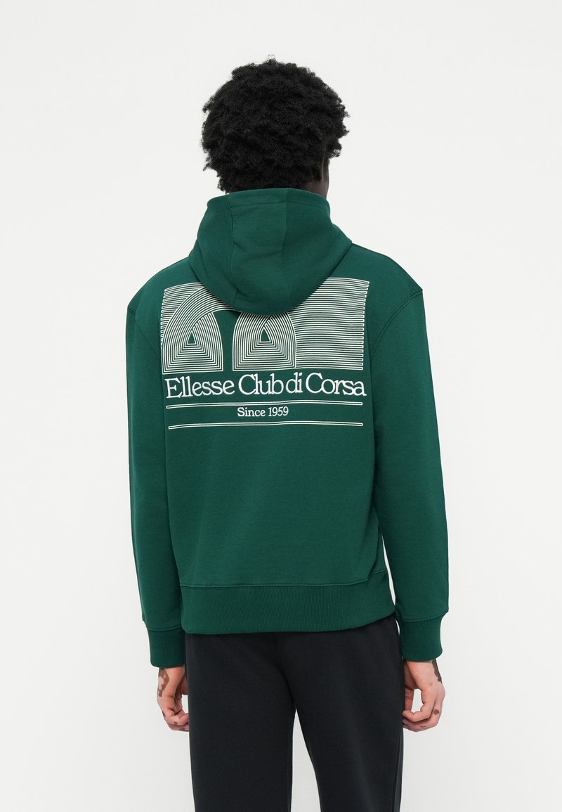 Grøn hoodie med snor og kengurulomme. Har en hvid grafisk tryk af "Ellesse Club di Corsa" på ryggen og linjer ovenfor.