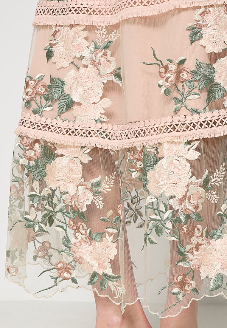 Gonna a strati rosa pallido con complessa ricamata floreale in tonalità pastello, realizzata in tessuto trasparente e dettagli con orlo a scallop.