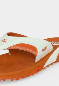 Πορτοκαλί και λευκό σανδάλι Reef με υφή στη σόλα, λουράκι βέλκρο και ανυψωμένη σόλα σχεδιασμένο για casual χρήση.