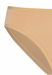 Culotte en coton beige avec une texture douce, une taille élastique et des coutures plates. Le design est sans couture et présente une finition lisse.