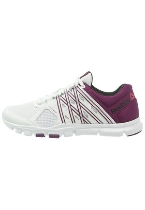 Chaussure de sport Reebok blanche et violette avec empeigne en mesh, motifs géométriques sur les côtés et semelle amortissante, vue de côté.