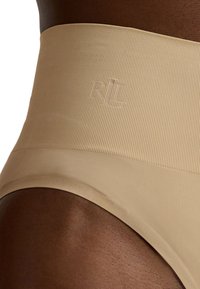 Beige sömlösa högmidjade trosor med ribbad textur och präglad logotyp, med en jämn yta och inga synliga sömmar för komfort.