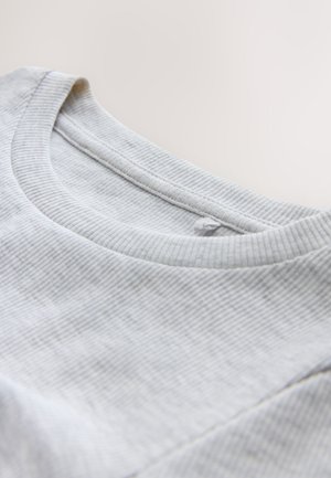 Svetlosivé bavlnené tričko s rebrovaným okrúhlym výstrihom. Mäkká textúra s minimálnym vzorom a jemnými švami pozdĺž výstrihu.