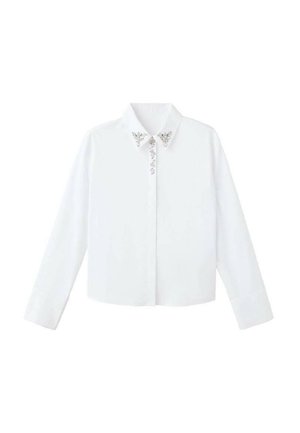 Camisa blanca de manga larga con cuello, que presenta adornos plateados cerca del escote y un corte recto y entallado. Textura de tela suave.