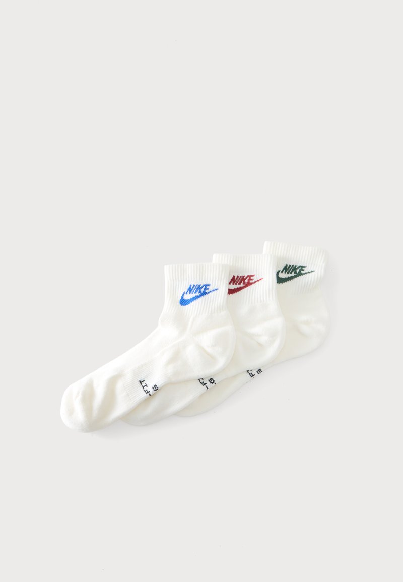 Τρία ζεύγη λευκές κάλτσες αστραγάλου Nike με μπλε, κόκκινο και πράσινο λογότυπο στοιβαγμένα σε απλό λευκό φόντο.