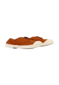 Un par de zapatillas bajas de lona marrón con suelas y puntas de goma blanca sobre un fondo blanco.