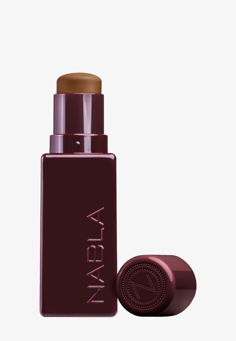 Burgundy rectangular foundation stick with a rounded top cap, featuring embossed logo and smooth texture. Cap is separate from the base.
