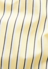 Tissu lisse à rayures verticales en jaune pâle, blanc et gris foncé, présentant de douces pliures et une texture délicate.