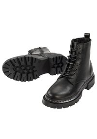 Botas de tobillo de cuero negro con punta redonda, cordones en la parte delantera y una suela gruesa y robusta. Presenta un borde cosido y una lengüeta para tirar.