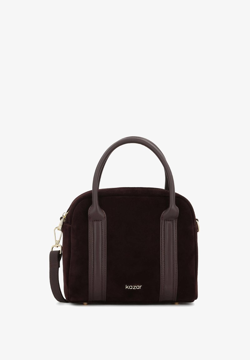 Maža tamsiai ruda zomšos rankinė su dviem apvaliais rankenomis, oda detalėmis, auksinėmis detalėmis ir "kazar" logotipu priekyje.