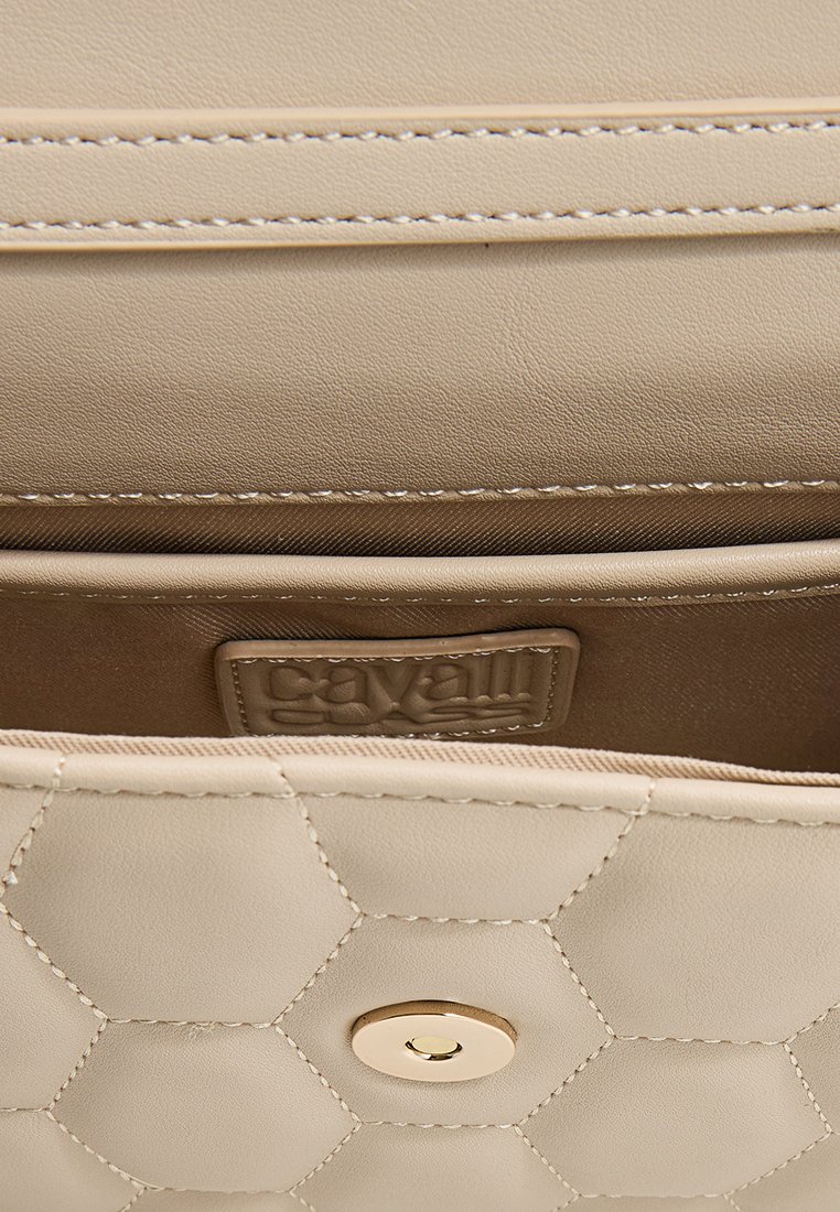 Bolso de mano de cuero beige con un patrón hexagonal acolchado, que presenta un cierre con herrajes dorados y una etiqueta interior de marca. Textura suave.