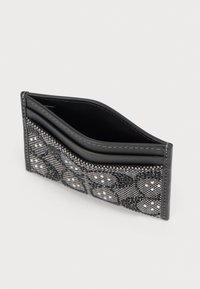 Μαύρο πορτοφόλι με υφασμάτινη επιφάνεια υφής, που διαθέτει γεωμετρικό σχέδιο και δερμάτινο περίβλημα. Το εσωτερικό είναι λείο και σκούρο.