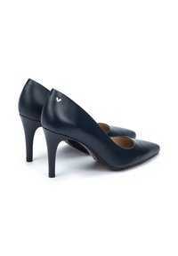 Zapatos de tacón alto de cuero azul marino con puntera afilada y un detalle de corte. Incluye un logo de acento dorado en el tacón.