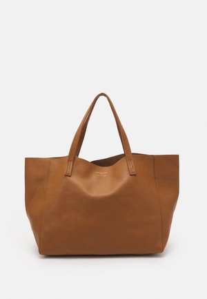 Brun läderväska med strukturerad yta, bred öppen topp och två robusta handtag. Har en minimalistisk design utan synliga metalldetaljer.