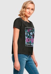 Black cotton t-shirt with a boxy design, featuring a colorful AC/DC graphic labeled "Highway to Hell" on the front. Short sleeves, crew neck.