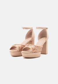 Nude hoge hak sandalen met een chunky platform, voorzien van sequinversieringen op de voorste band en een enkelbandje voor extra ondersteuning.