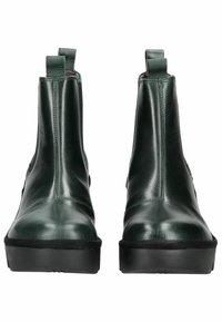 Stivaletti in pelle verde con pannelli laterali elastici, punta rotonda e suole in gomma nera; texture liscia e dettagli di cucitura minimi.