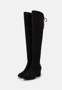 Botas negras sobre la rodilla hechas de suave gamuza, con tacón cuadrado y un detalle de lazo en la parte posterior para un ajuste ajustable.
