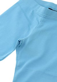 Jasnoniebieska koszula z krótkim rękawem, wykonana z gładkiego, miękkiego materiału. Posiada okrągły dekolt oraz subtelne przeszycia wzdłuż szwów.