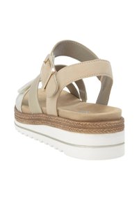 Beige sandals with multiple straps and a buckle detail. Textured footbed, thick wedge sole with brown and white elements.