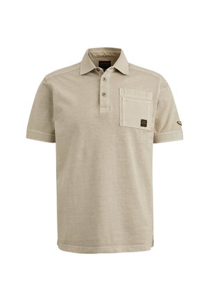 Beżowa koszulka polo z krótkim rękawem, wykonana z miękkiego materiału, z zapinanym kołnierzykiem, kieszonką na piersi oraz małą naszywką z logo na rękawie.