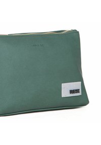 Rektangulær grøn taske lavet af tekstureret stof, med en guldrivet og et hvidt label med "RENEW VITA" i sort skrift.