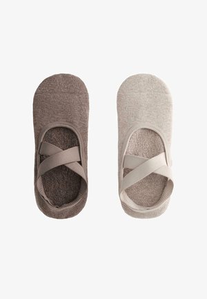 Kaksi paria pehmeitä, liukumattomia balettityylisiä tohveleita tummanruskeana ja vaaleanbeigenä, joissa on ristiin menevät nauhat ja kuvioidut pohjat.