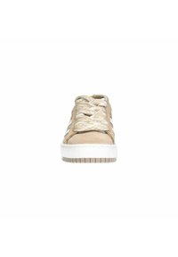 Baskets en daim beige avec une semelle en caoutchouc blanche, des lacets texturés beige et crème, et des rayures blanches sur les côtés, vues de face.